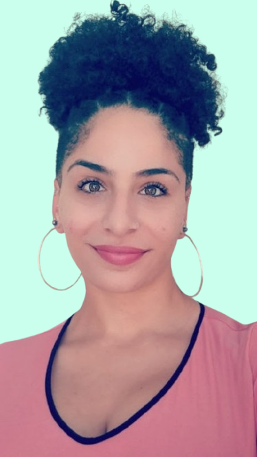 Headshot of Sasha Reinoso, a woman wearing earrings and a pink blouse.